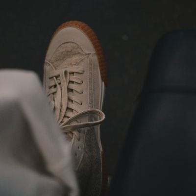 Close-up on athletic shoes on a dark floor.