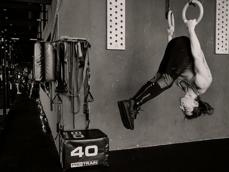 Man performing a controlled bodyweight exercise in a minimalist gym.